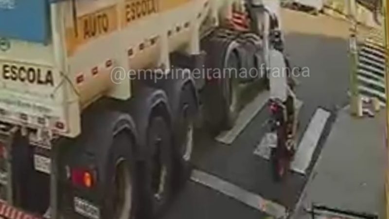 Câmeras de segurança registram acidente entre moto e carreta em Franca; motociclista por pouco não foi atropelado