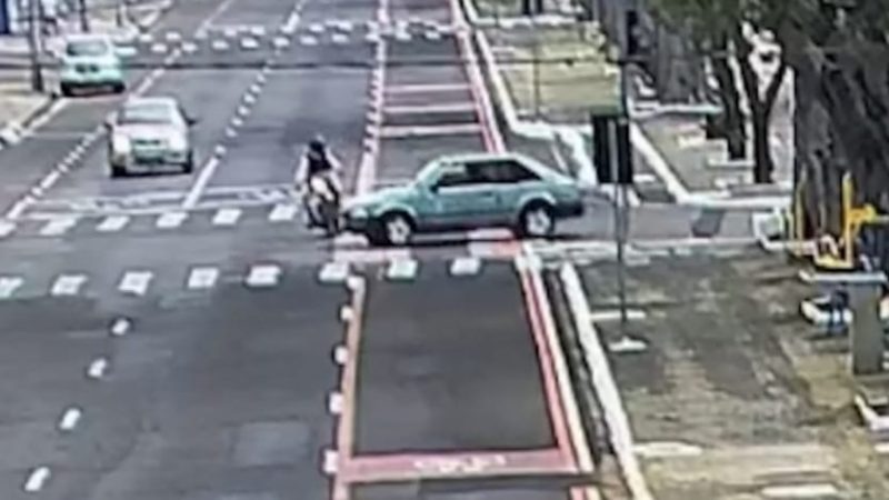 Câmera registra motorista realizando conversão proibida e atingindo motociclista em avenida
