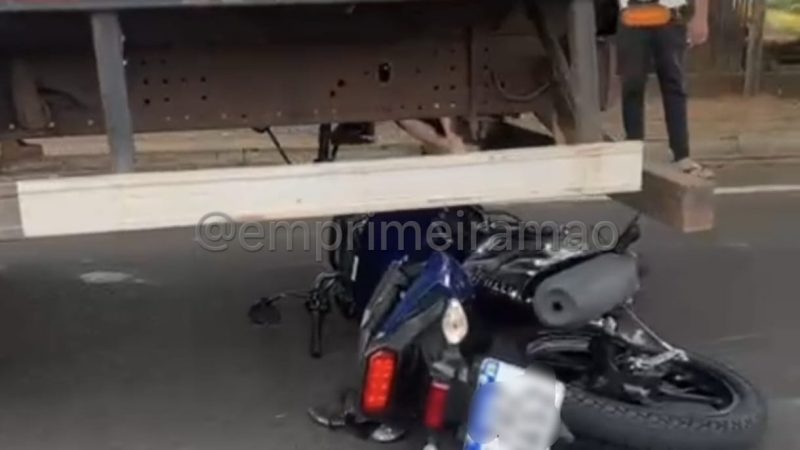 Moto vai parar debaixo de caminhão após acidente em avenida