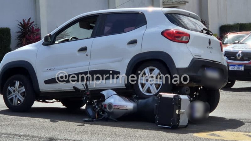 Câmera registra motociclista derrapando e moto parando debaixo de carro em avenida